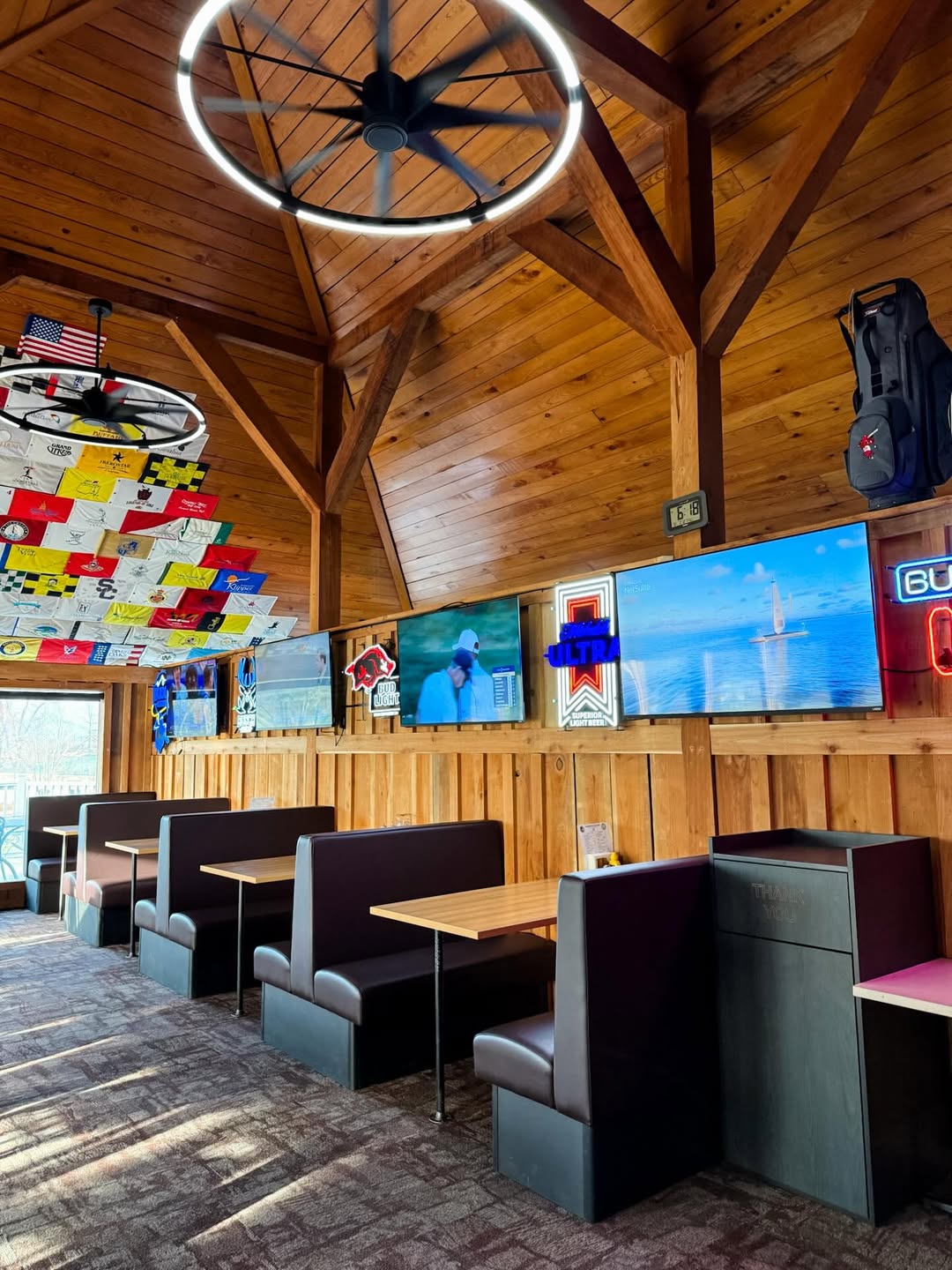 The 19th-hole bar and grill with leather booths and TVs at The Creeks clubhouse